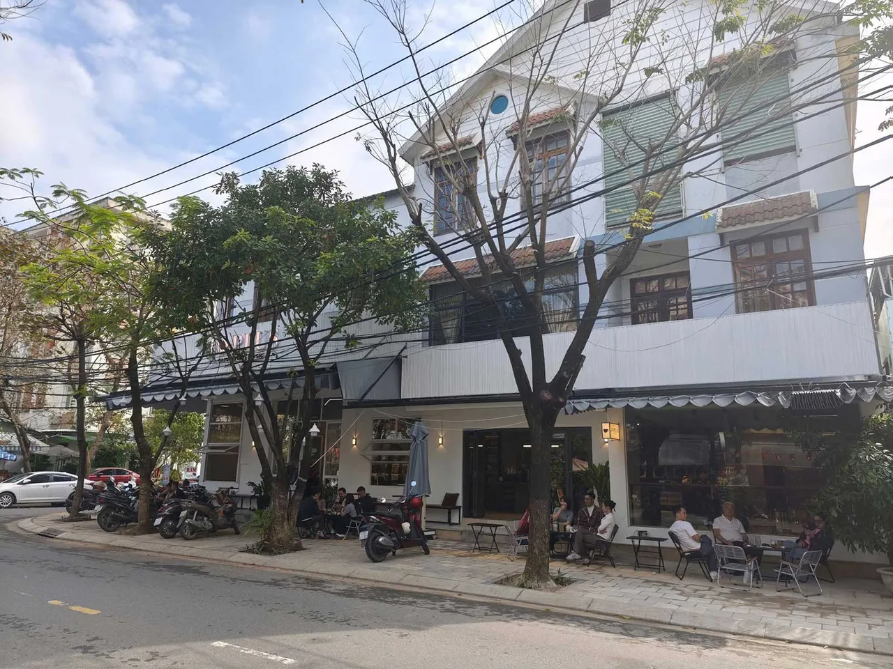 40Plus Cafe & Vinyl Music의 매장 정면 건물 전체 모습 매장 앞에 노상 테이블은 동네 주민 들이 커피를 마시고 있다