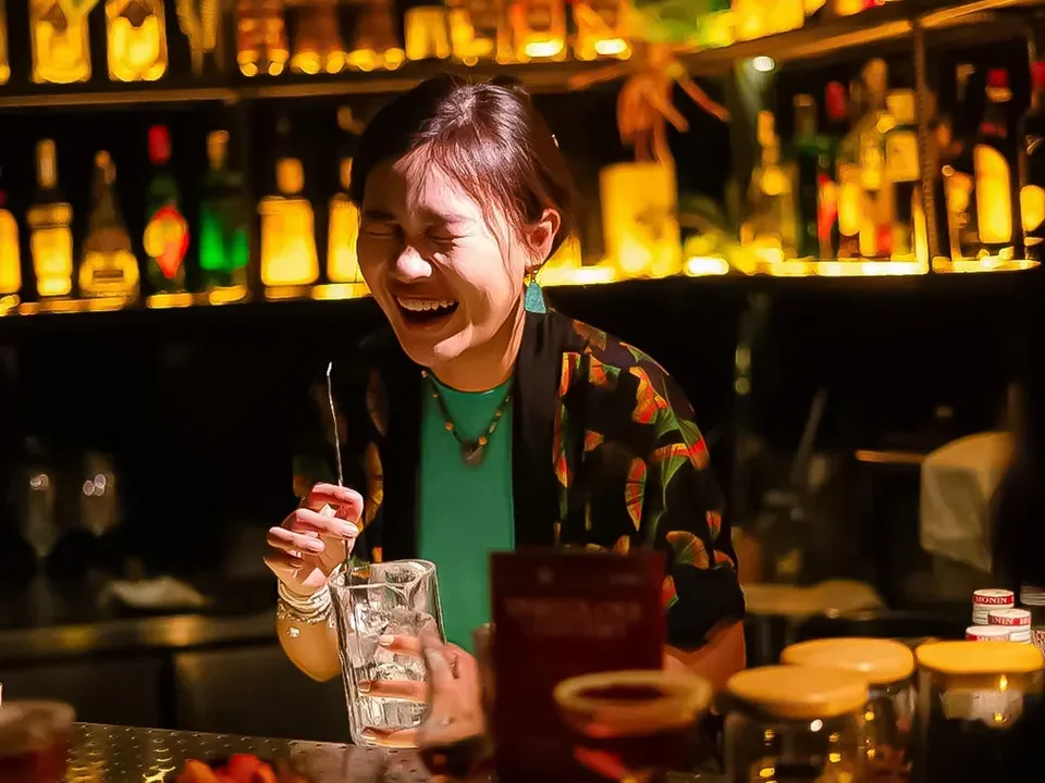 켓하이 칵테일바 주류 진열대 앞에서 음료를 준비하는 바텐더
